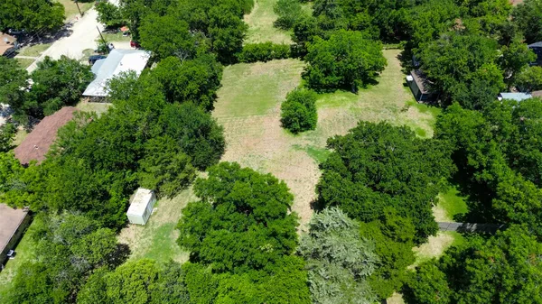 an aerial view of residential house with outdoor space and trees all around