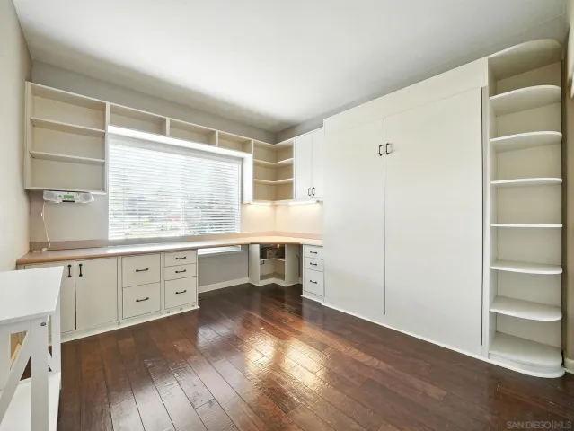 a kitchen with granite countertop white cabinets and wooden floor