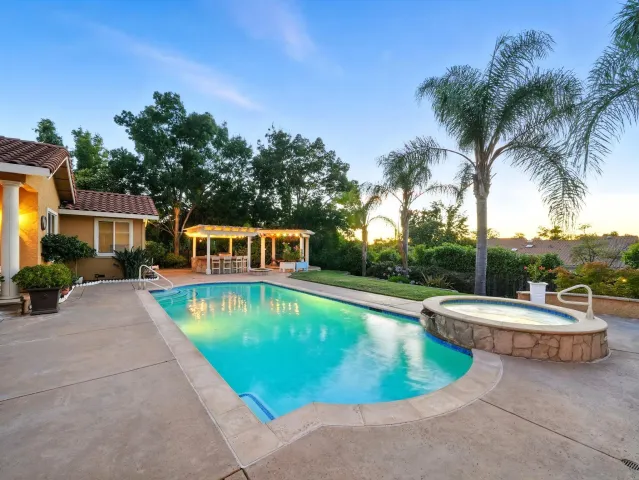 a view of a house with swimming pool and sitting area