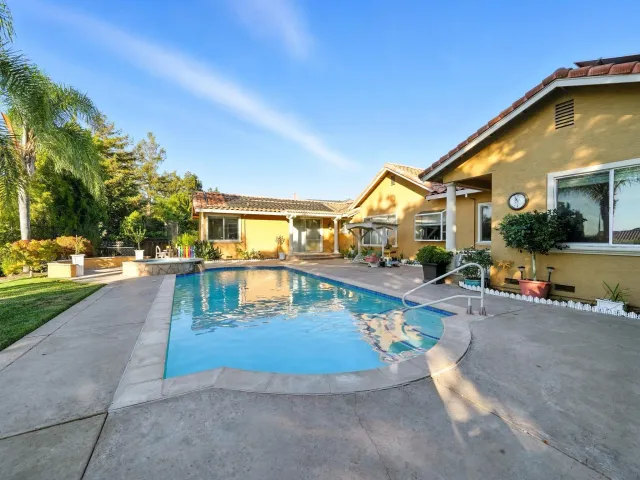 a view of a swimming pool with a bench and floor to ceiling window