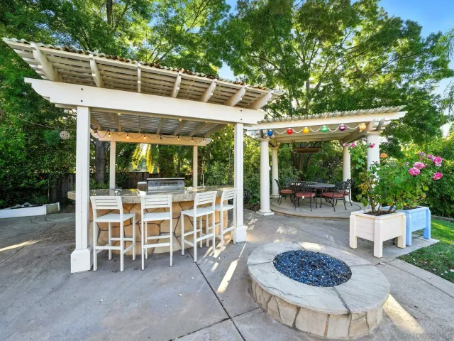 a patio with a table and chairs and potted plants