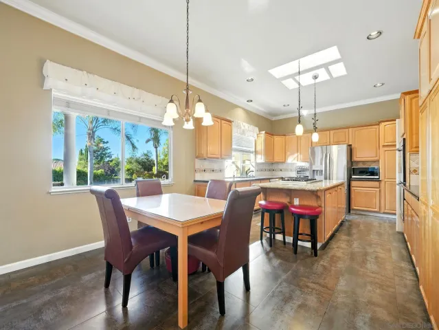 a dining room with a table chairs and a kitchen view