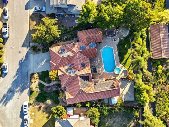 an aerial view of a house with swimming pool and outdoor seating