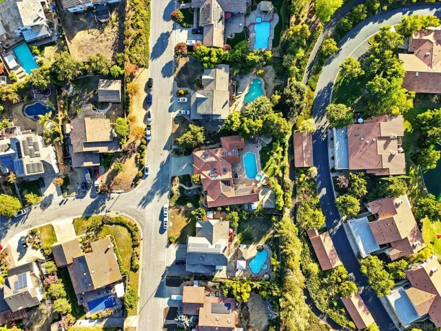 an aerial view of residential houses with city and mountain view in back