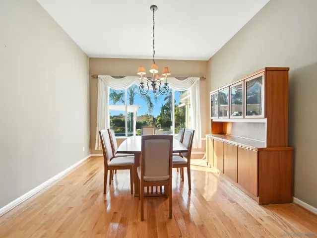 a dining room with furniture a chandelier and wooden floor