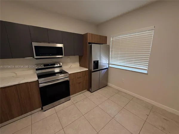 a kitchen with granite countertop a refrigerator and a stove