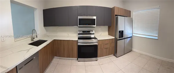 a kitchen with stainless steel appliances a stove a sink and a microwave