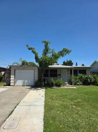 a front view of a house with a yard and potted plants