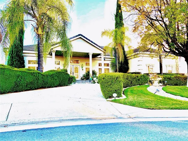 a front view of a house with a yard and potted plants