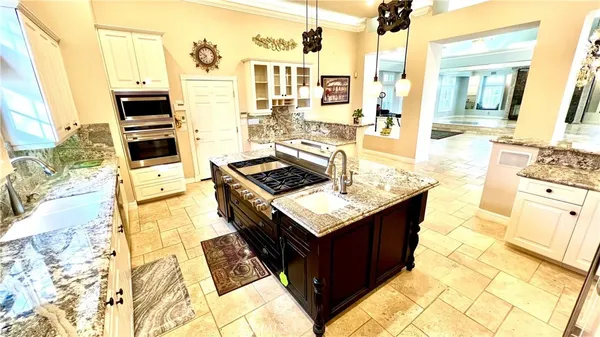 a kitchen with a stove a sink and a window