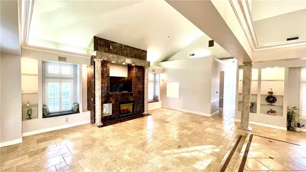 a view of a big room with windows and chandelier fan