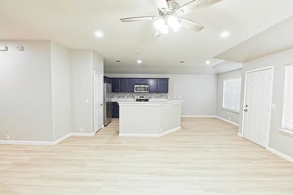 a view of a kitchen with wooden floor and a sink