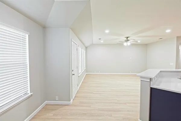 a living room with stainless steel appliances kitchen island granite countertop a stove and a refrigerator