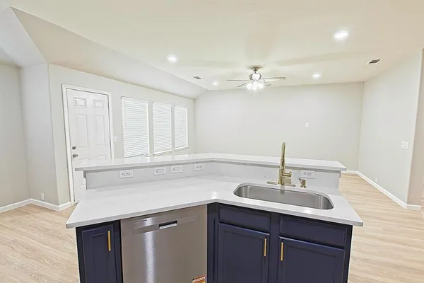 a kitchen with granite countertop white cabinets and black appliances