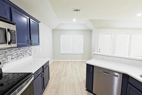 a kitchen with stainless steel appliances granite countertop a stove and a refrigerator