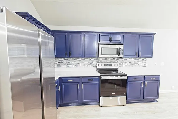 a kitchen with granite countertop a stove and a refrigerator