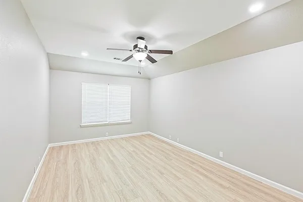 a view of a room with wooden floor and ceiling fan