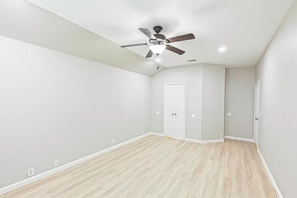 a view of a big room with wooden floor and a ceiling fan