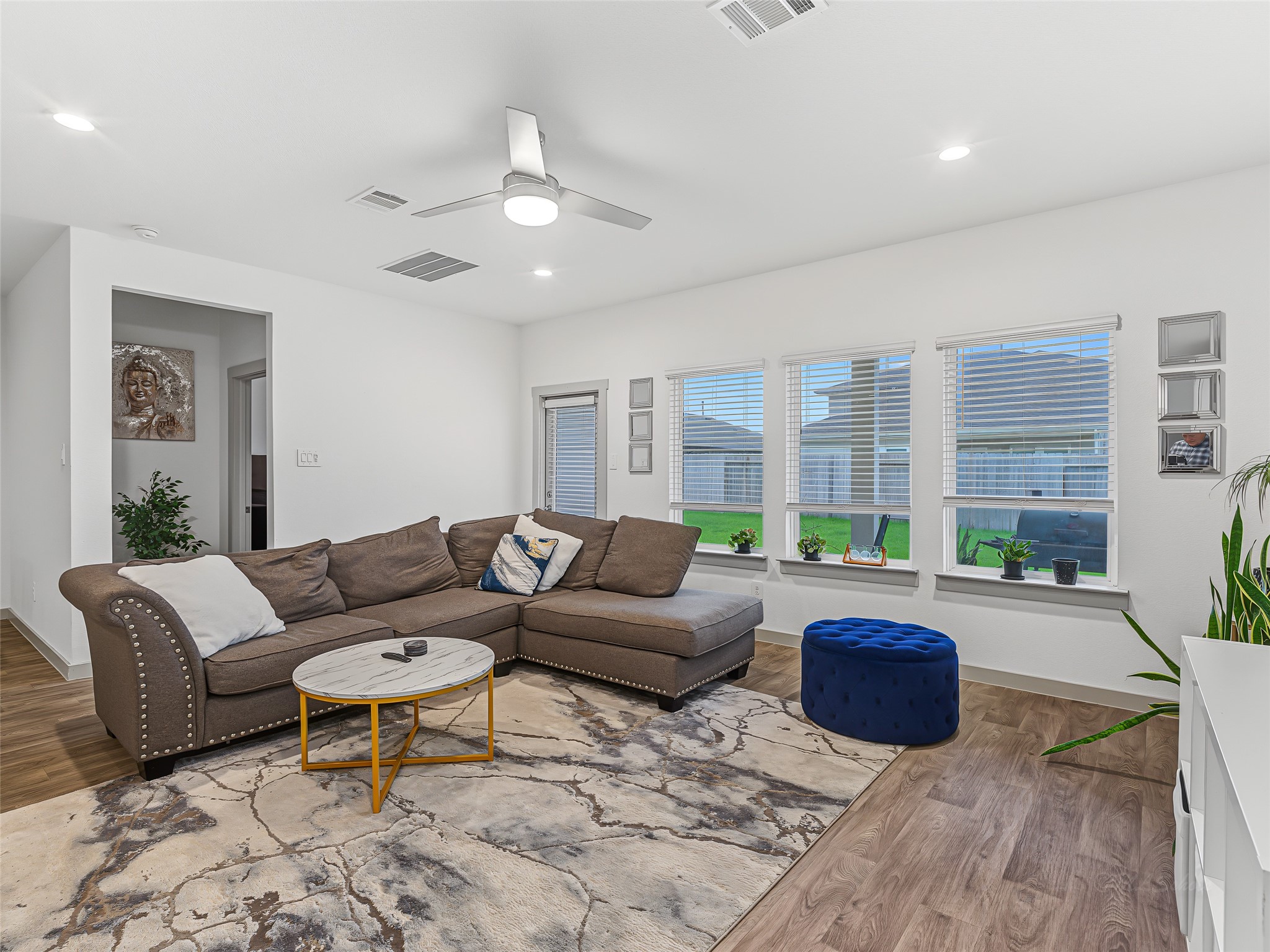 8043 Milam Lane Rosharon, TX 77583 - Photo 16 of 41 A wall of three oversized windows with custom blinds floods the room with beautiful natural light, while a glass exterior door offers direct access to a glimpse of the green backyard.