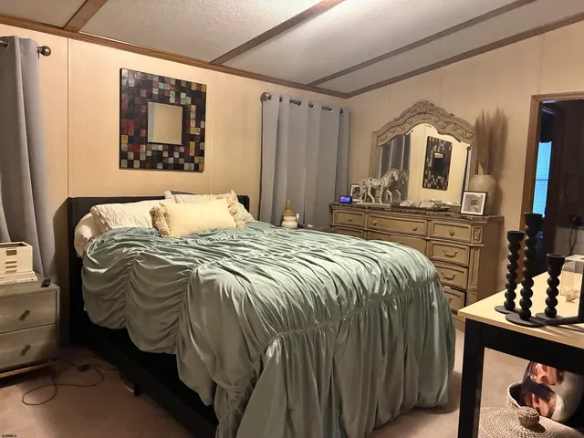 a bedroom with a bed a painting on the wall and a window