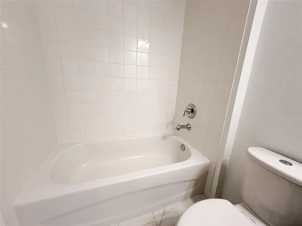 a white bath tub sitting next to a white toilet