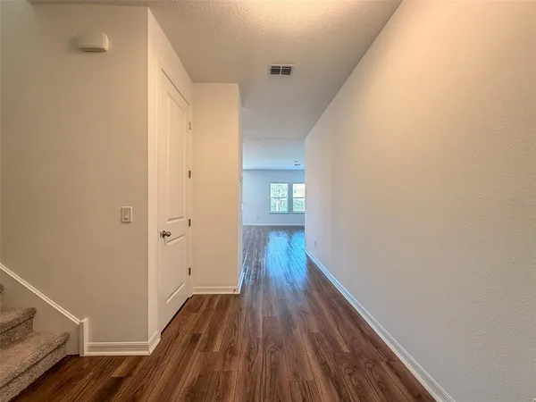 a view of a hallway with wooden floor and staircase