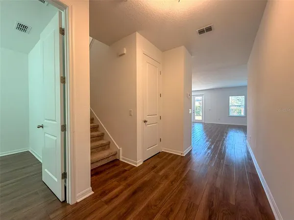 a view of a hallway with wooden floor and staircase