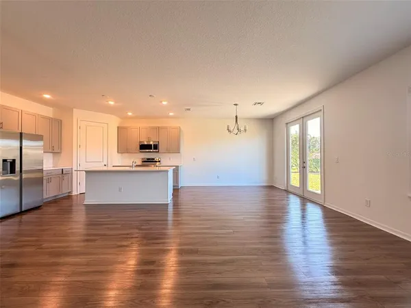 a view of kitchen with kitchen island wooden floors and stainless steel appliances
