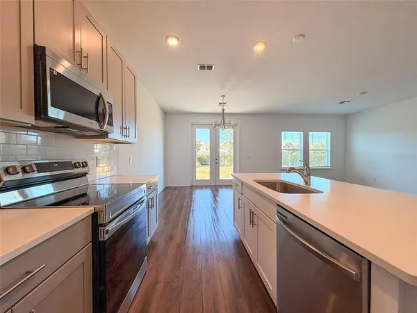 a kitchen with wooden floor and stainless steel appliances
