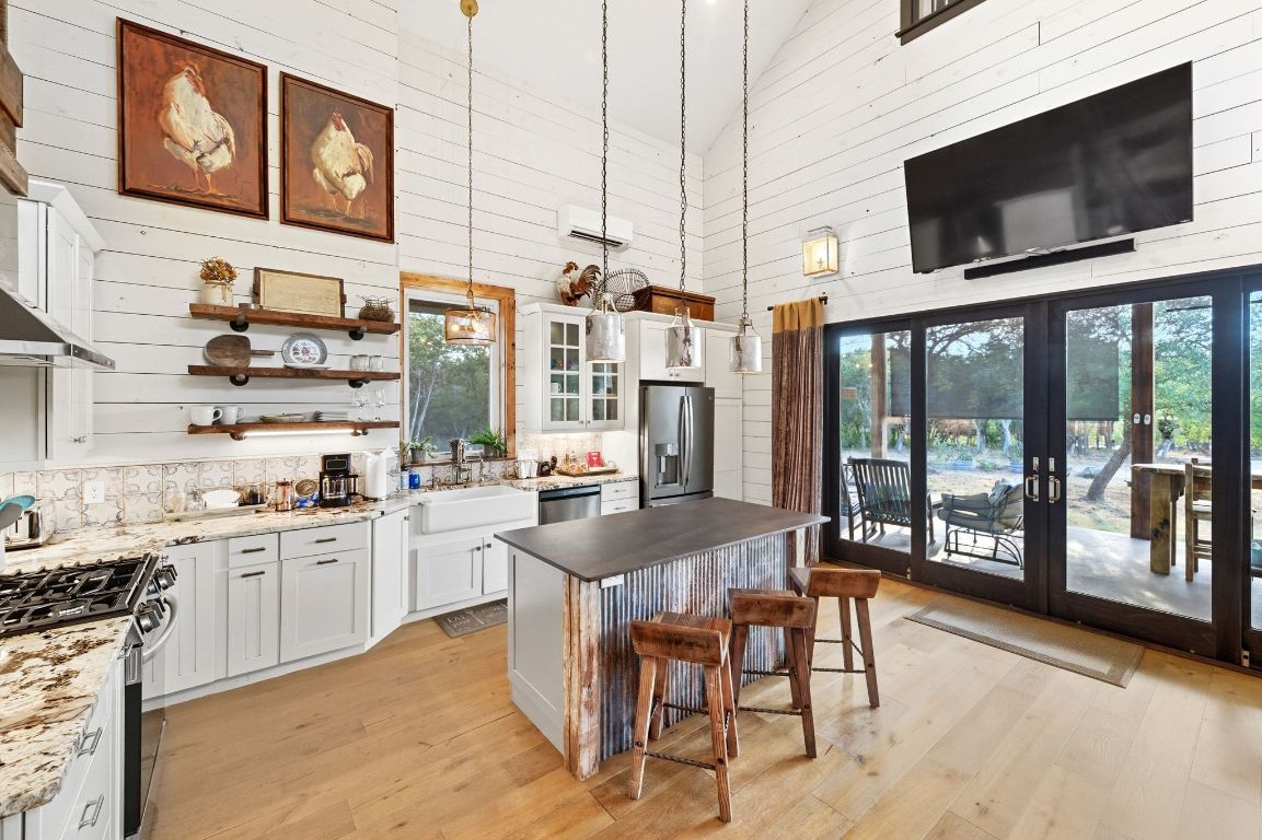 1910 Sandy Point Road Wimberley, TX 78676 - Photo 20 of 40 a kitchen with stainless steel appliances granite countertop a stove and cabinets