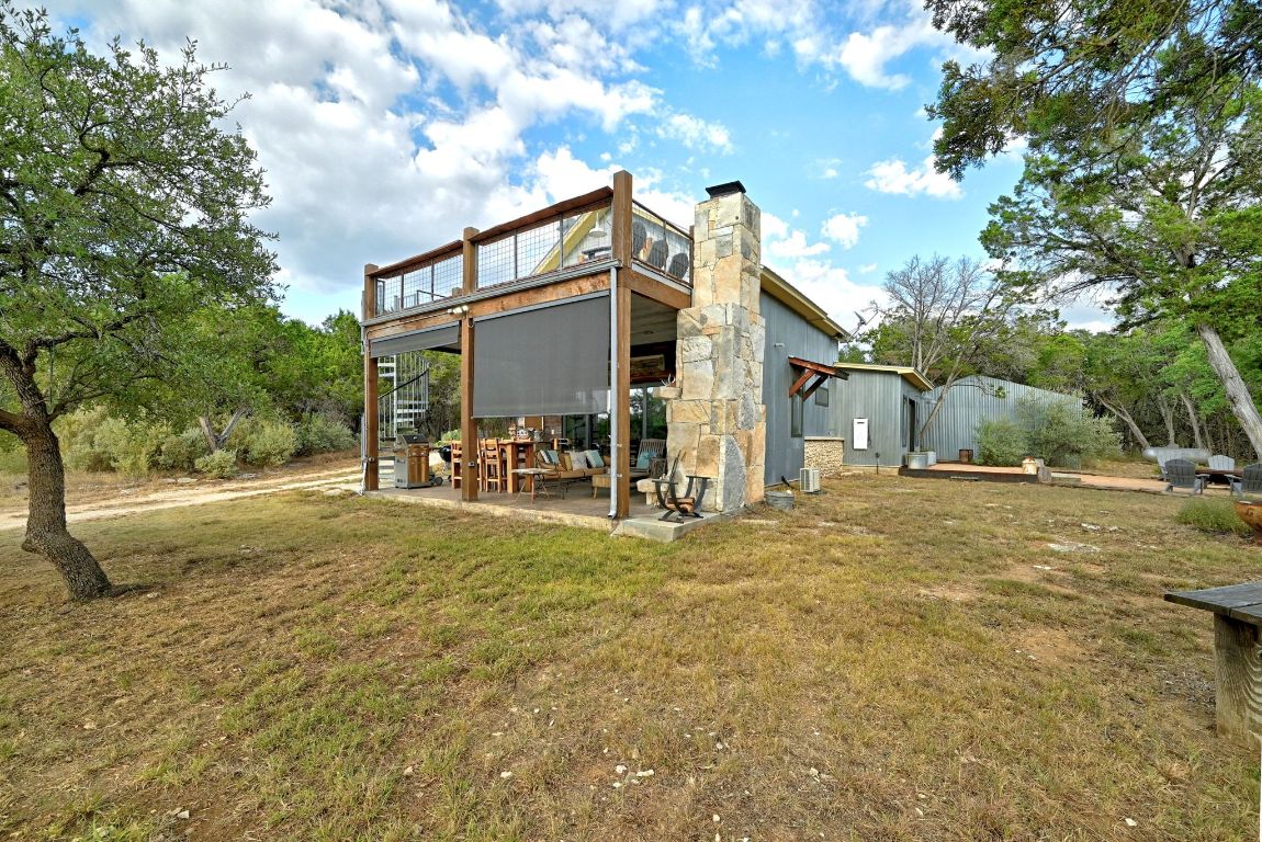 1910 Sandy Point Road Wimberley, TX 78676 - Photo 4 of 40 a view of a house with backyard and a tree