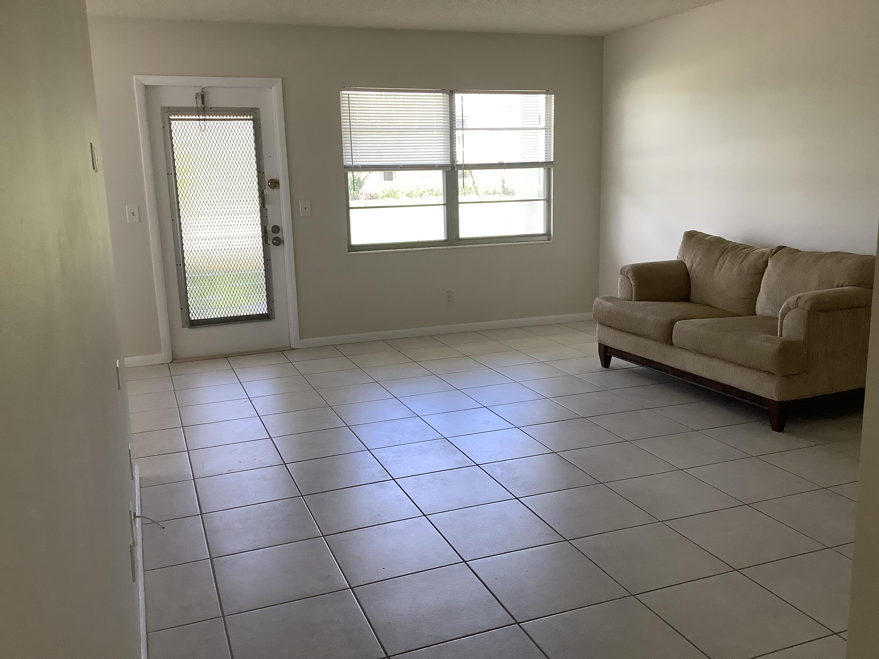 560 Fanshaw North, Unit 560 Boca Raton, FL 33434 - Photo 11 of 26 a living room with a white checkered floor and a window
