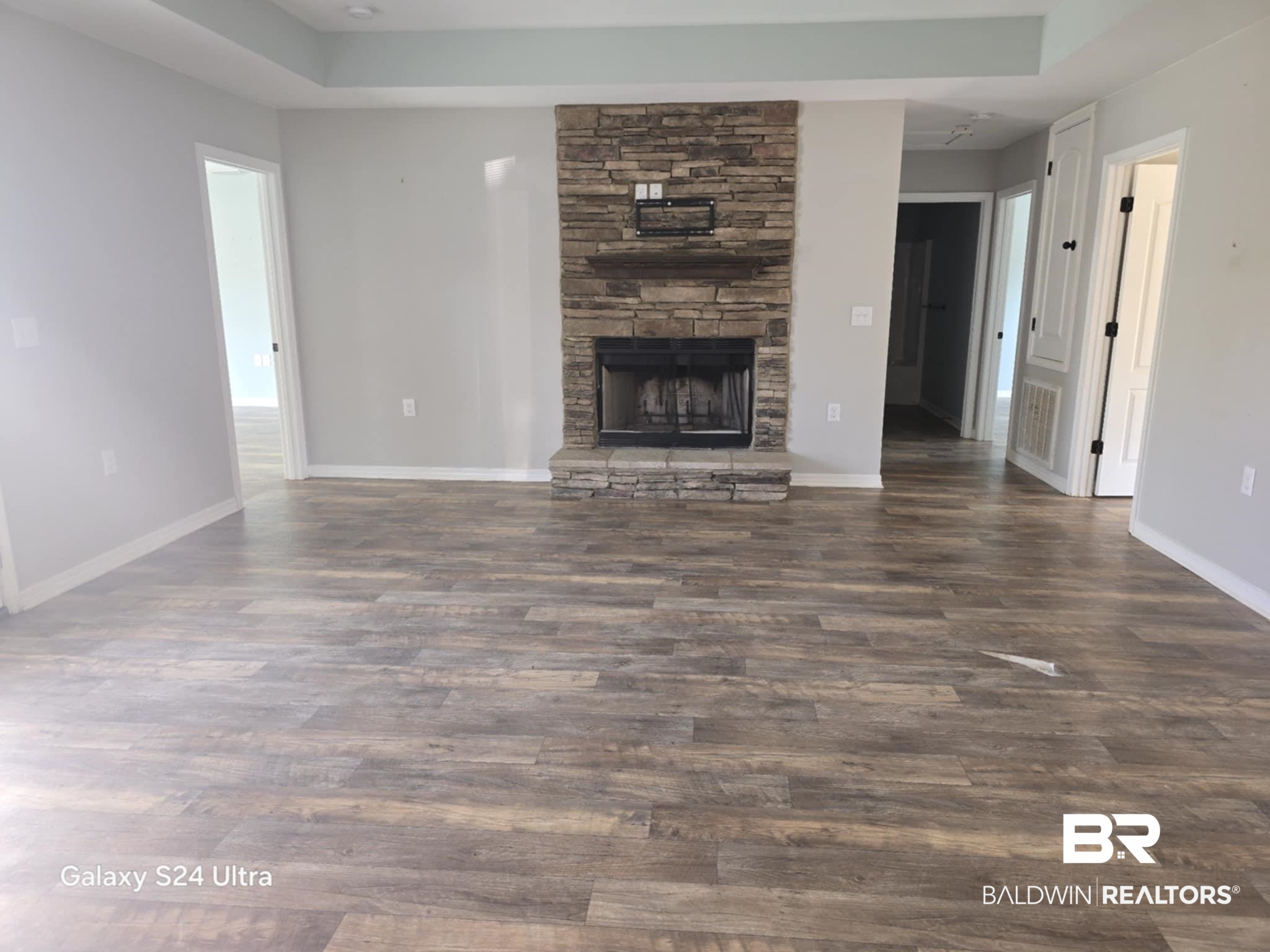 546 Wolf Log Road Flomaton, AL 36441 - Photo 2 of 15 Unfurnished living room featuring a raised ceiling, a fireplace, and hardwood / wood-style flooring