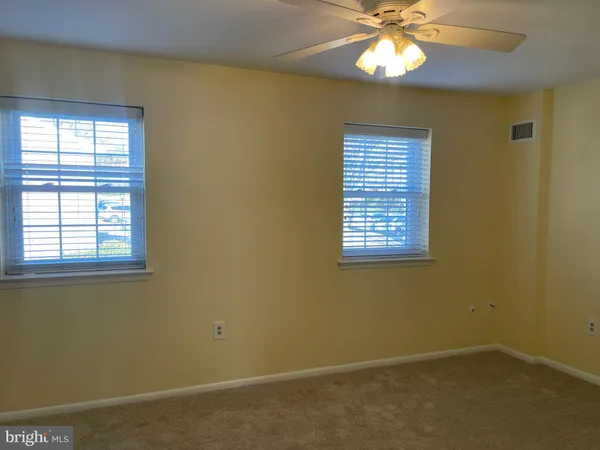 an empty room with window and chandelier fan