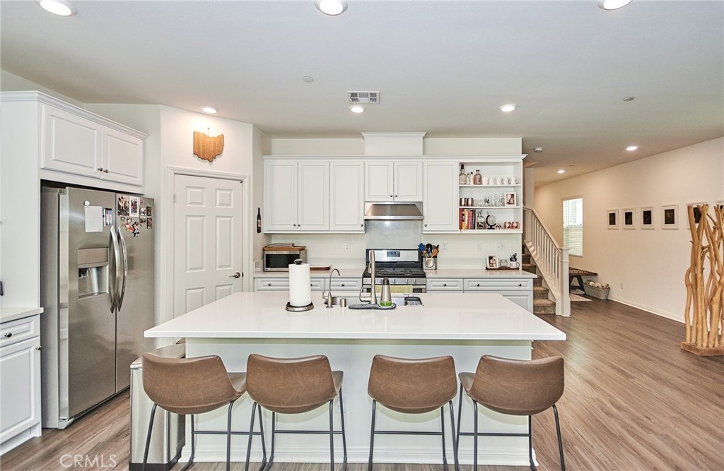 2375 Vineyard Street Upland, CA 91786 - Photo 8 of 58 a kitchen with stainless steel appliances granite countertop a dining table chairs refrigerator and microwave