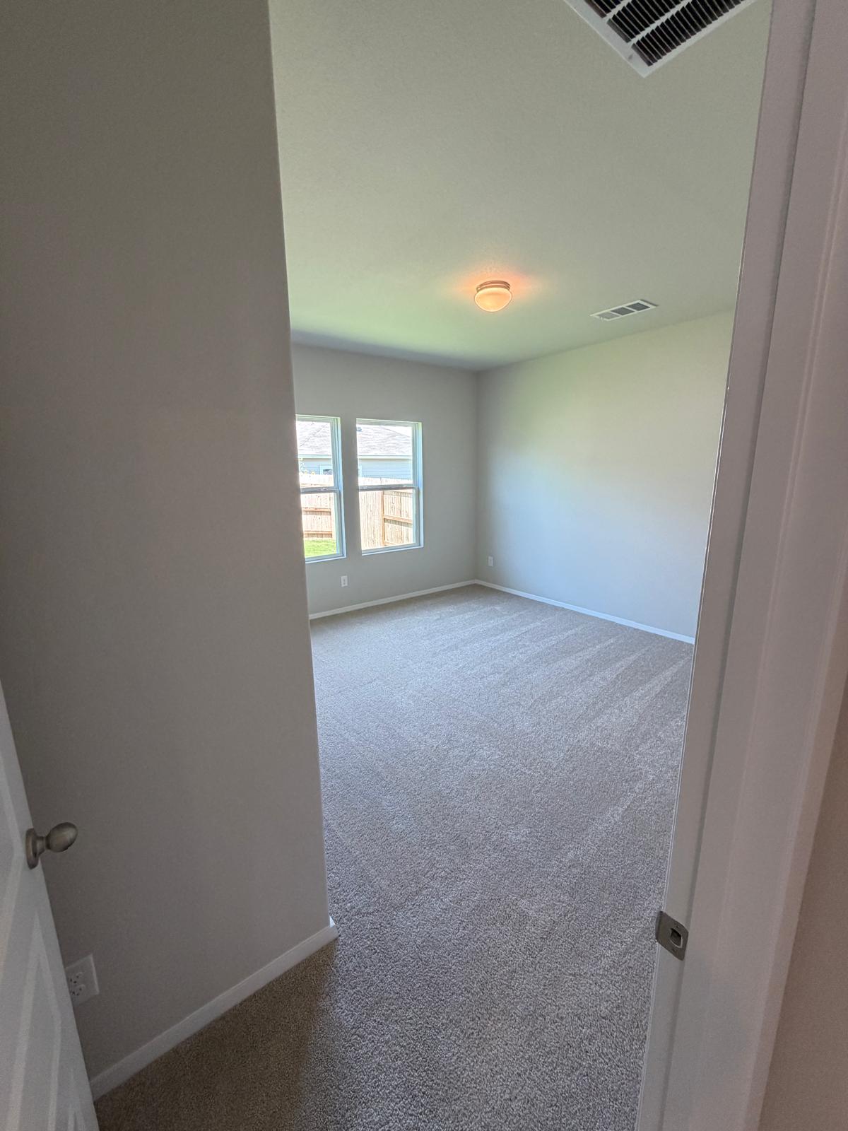 2612 Towy Road Manor, TX 78653 - Photo 17 of 35 A spacious, naturally illuminated room features plush carpeting and multiple windows.