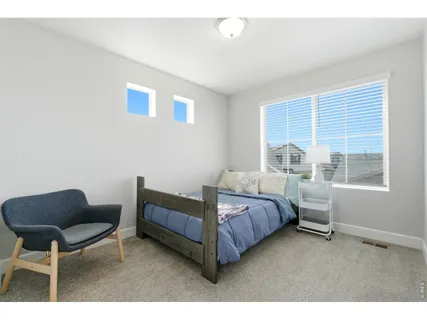 a bedroom with a bed chair and a window