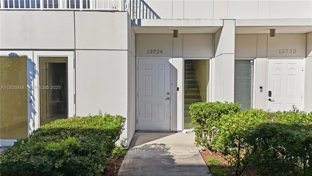 a couple of potted plants in front of door