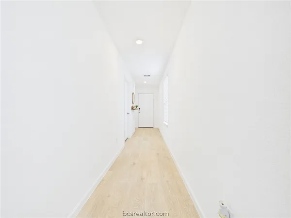 a view of a hallway with wooden floor