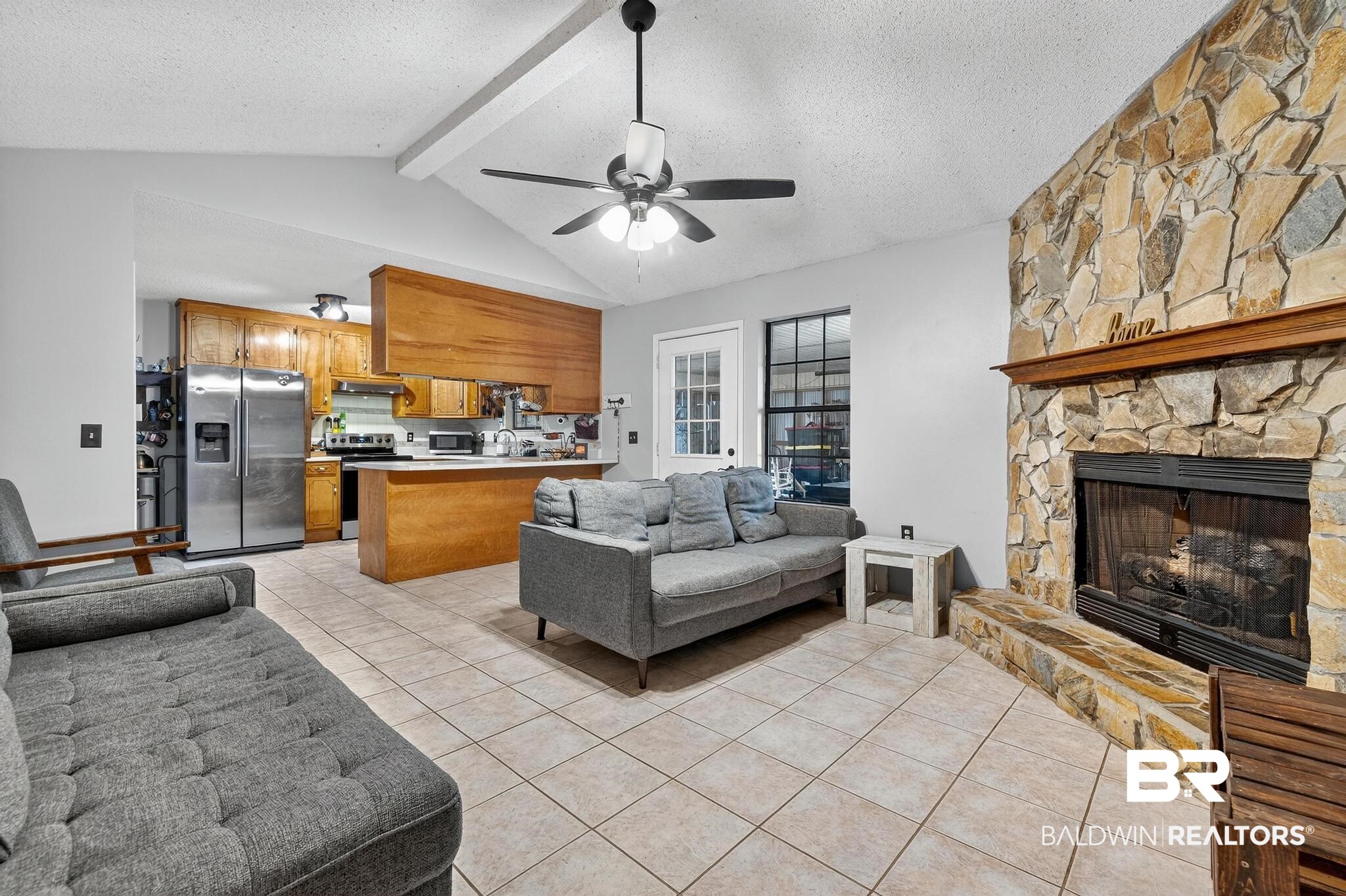 21895 2nd Street Silverhill, AL 36576 - Photo 18 of 43 Living area with light tile floors, a stone fireplace, and a ceiling fan