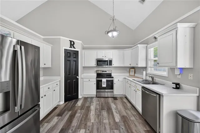 a kitchen with white cabinets and stainless steel appliances