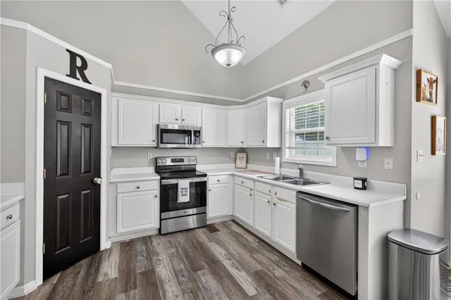 a kitchen with a sink cabinets stainless steel appliances and a window