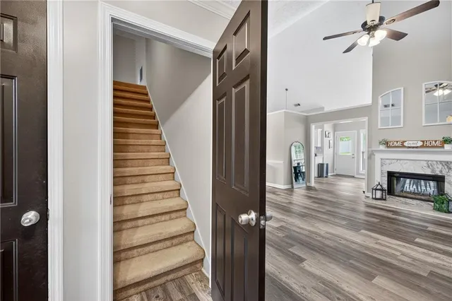a view of a hallway to a livingroom with wooden floor and fireplace