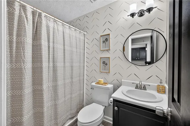 a bathroom with a toilet sink and mirror