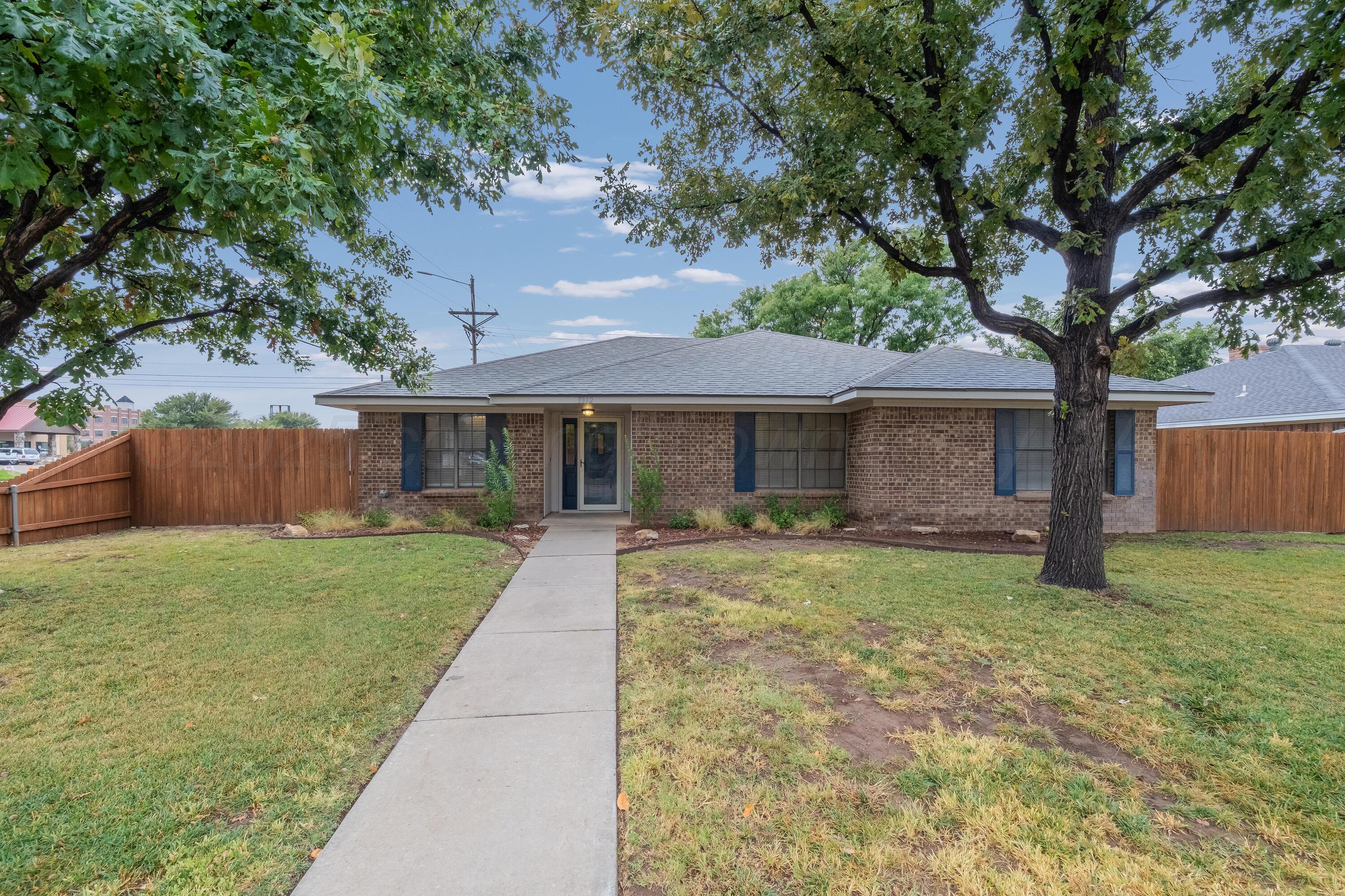 a front view of a house with a yard and an tree