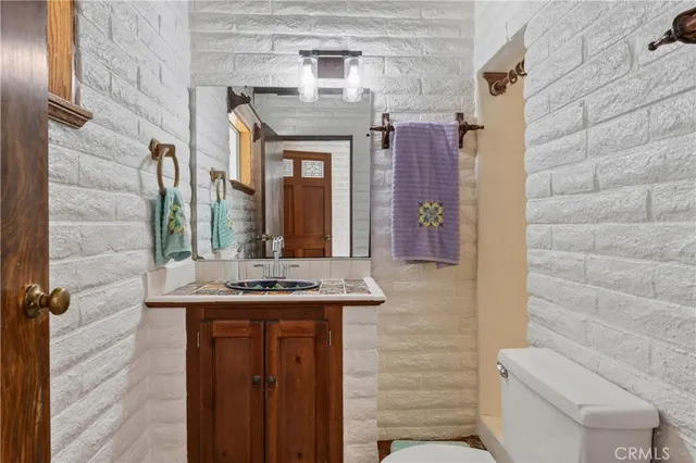 a bathroom with a granite countertop sink a toilet and a shower