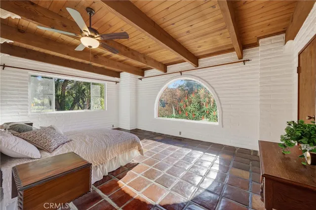 a bed sitting in a bedroom next to a window