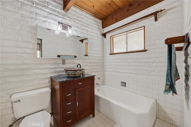 a bathroom with a granite countertop sink a toilet and bathtub