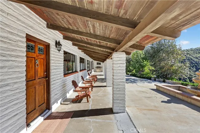 a view of a patio with table and chairs with wooden floor and fence
