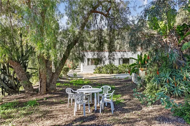 a view of house with backyard and sitting area